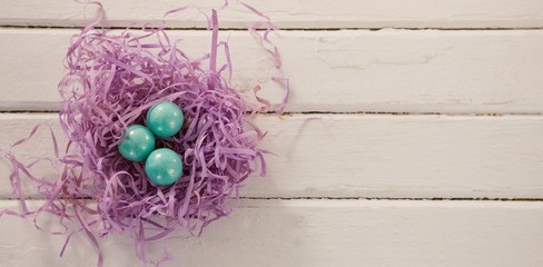 Wall Mural - Turquoise Easter eggs in violet nest