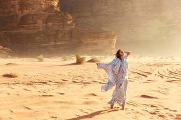 Stylish girl in white dress in Wadi Rum desert in Jordan