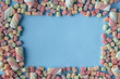 © Andrey Cherkasov - Colorful Candy Background. Small colored Marshmallows on blue table. Top view, celebration concept, copy space for text