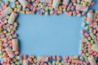© Andrey Cherkasov - Top view of pastel colored marshmallow on a blue background. Minimalism style.