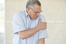 Senior Man Holding His Left Arm In Pain