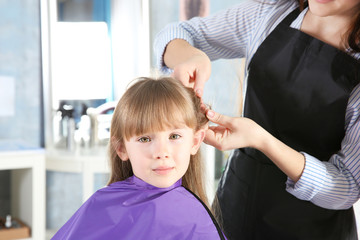 Wall Mural - Cute little girl in hairdressing salon