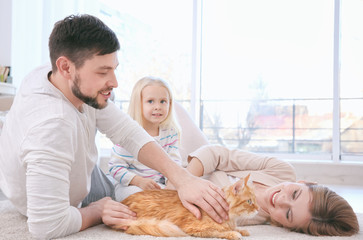 Canvas Print - Mother, father and their daughter with cat at home