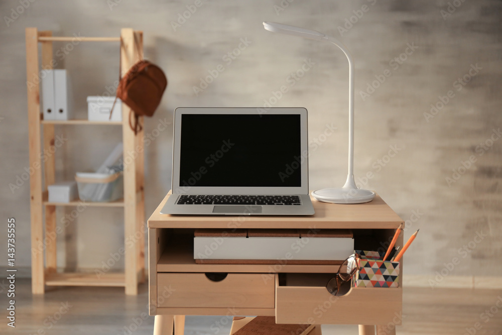 Stand-up desk with laptop in room