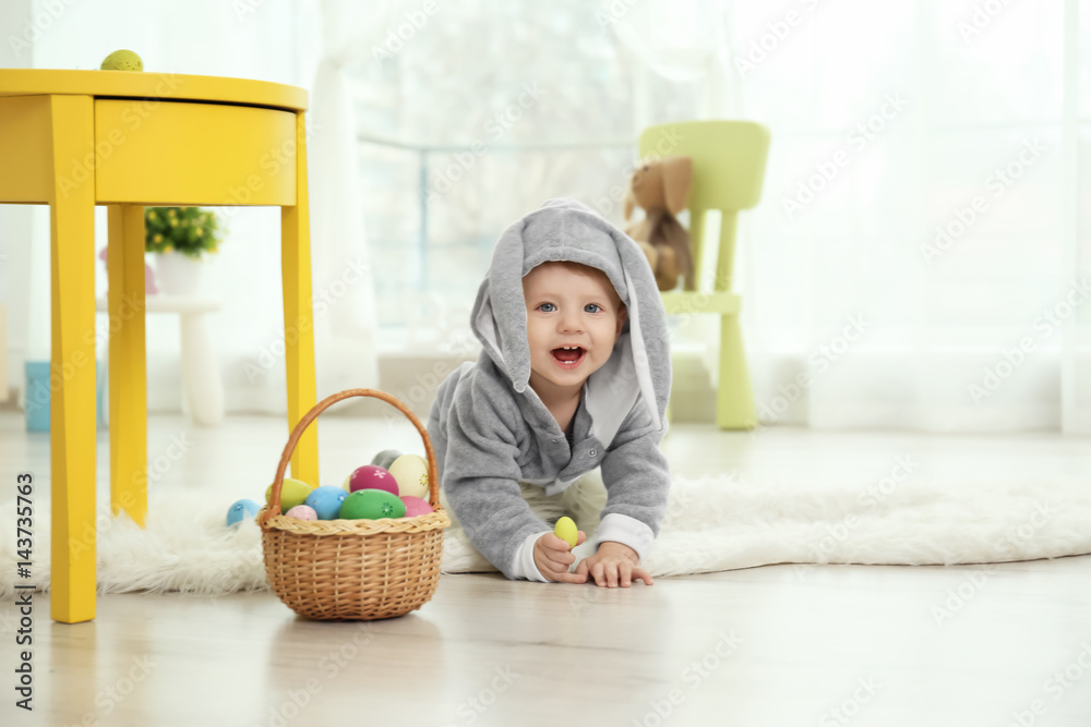 Cute little baby in bunny costume playing at home