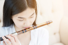 Asian Girl Playing Bamboo Flute