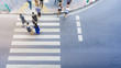 top view of group men and women and people walk on the crosswalk with white sign pedestrian on the city street (aerial city street view)