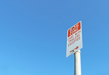 red and white Bus Zone sign in a blue sky