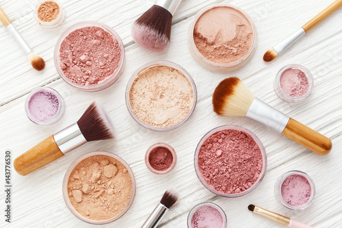 Fotomural Makeup powder and brushes on white wood flat lay