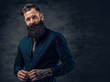 © Fxquadro - Bearded tattooed male dressed in dark blue jacket.