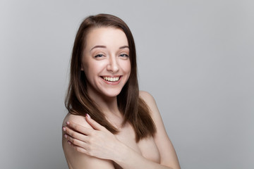 Wall Mural - Isolated on gray background studio portrait of young brunette with manicure on nails