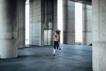 Wall Mural - Woman running in urban environment.