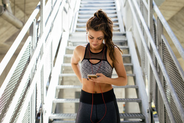 Wall Mural - Woman in sport wear using mobile phone
 