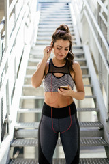 Wall Mural - Woman in sport wear using mobile phone
 