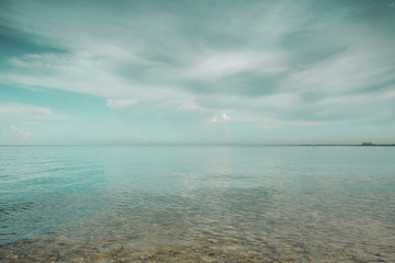 Beautiful sunset over sea with reflection in water, majestic clouds in the sky with beautiful beach and tropical sea in Miami Beach. Florida. USA.