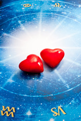 Wall Mural - red hearts lying on a hosroscope and zodiac signs like a astrology and love concept