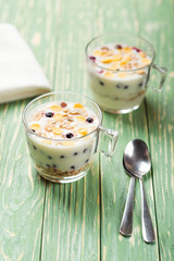 Morning granola with yogurt and berries on wooden kitchen table. Concept healthy breakfast.