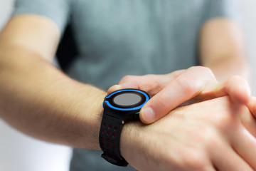 Hand holding black smartwatch with technology screen