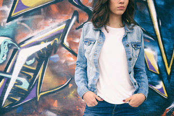 Canvas Print - Young woman in blank t-shirt against graffiti wall