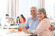 © Africa Studio - Beautiful mature couple with orange juice sitting at kitchen table