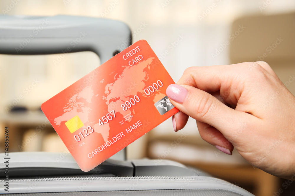 Female hand holding credit card on blurred background