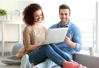 Canvas Print - Happy young couple with laptop at home