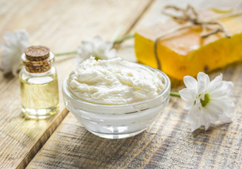 Wall Mural - homemade cosmetics with camomile herbs on wooden background