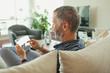 © phocal Media - Man using digital tablet at home.