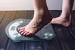 © Artem - Female feet standing on electronic scales for weight control