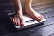 © Artem - Women's feet are on mechanical scales for weight control