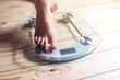 © Artem - Female feet standing on electronic scales for weight control
