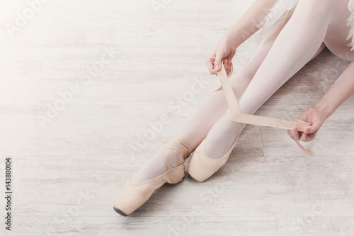 Obraz Dibond Balerina zakłada pointe baletki, pełne wdzięku nogi