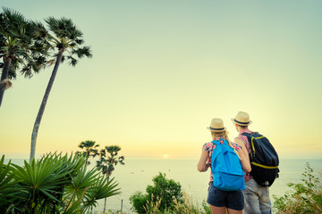 Wall Mural - Traveling and trekking concept. Young loving couple walking on mountains near the sea.