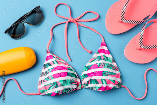 Fotomural Colorful swimsuit with beach accessories on blue background