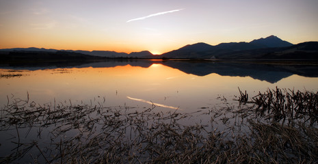 Wall Mural - Colorful sunset over lake and mountains