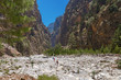The famous Samaria Gorge in the white mountains on the island of Crete in Greece. Tourists walking along the hiking trail ahead. Dry riverbed.
