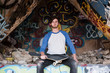 Portrait of young male skateboarder sitting on graffiti wall at ruined mine