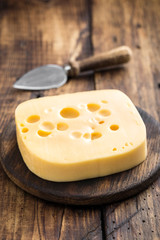 Delicious Swiss yellow cheese on dark wooden rustic background closeup