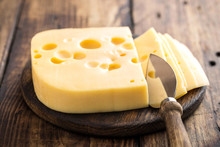 Delicious Swiss Yellow Cheese On Dark Wooden Rustic Background Closeup