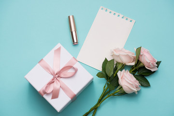 Sticker - Mother's Day concept. Bouquet of pink roses with gift box and lipstick. Blank paper note for copy space.