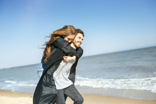 Happy Young Couple Spending Time On The Sea Shore In Spring