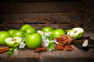 Wall Mural - Green apples, cinnamon on a wooden background