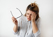 © shurkin_son - Closeup portrait of young upset woman suffering from stress thinking about something with headache holding her hands on head isolated on gray wall background. Negative human facial expression