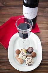 Sticker - Red wine and assorted chocolates on wooden background