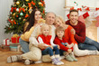 © Africa Studio - Happy family sitting in living room decorated for Christmas