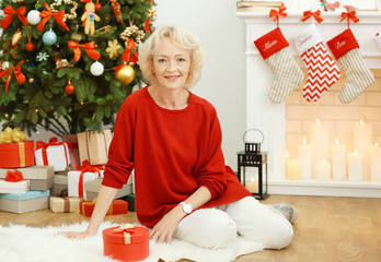 Sticker - Elderly woman sitting in living room decorated for Christmas