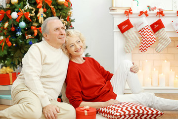 Wall Mural - Elderly couple near fireplace in living room decorated for Christmas