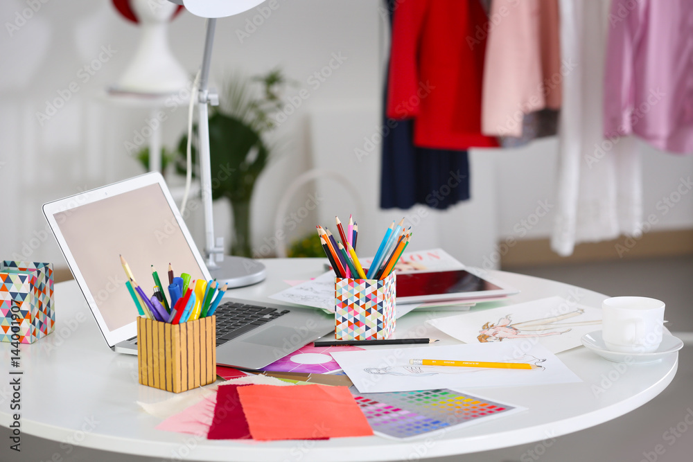 Fashion designer workplace with laptop on table