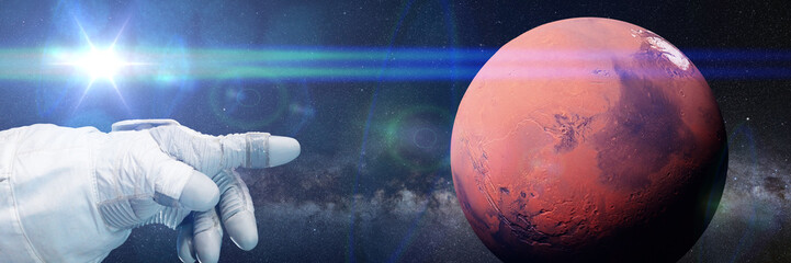 Wall Mural - astronaut pointing to the red planet Mars