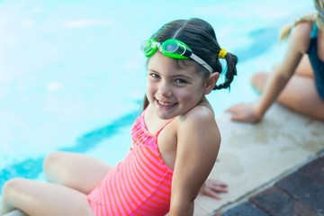 Wall Mural - Cute little girl resting at poolside